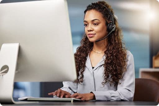 insurance agent working on a computer wearing a black headset with microphone